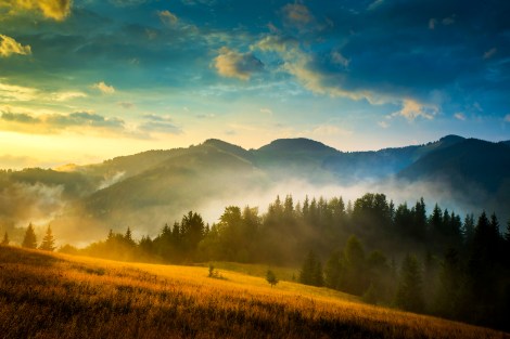 Amazing mountain landscape with fog and a haystack